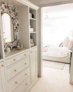 a bedroom with white furniture and floral wallpaper on the walls, along with a bed