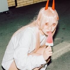 a woman with long blonde hair holding a piece of watermelon