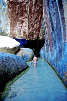 a man wading through a river surrounded by mountains and rocks, with the caption zipping in st thomas with a view of magens bay / carnival