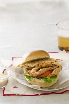 a chicken sandwich with lettuce, tomato and mayonnaise on a plate