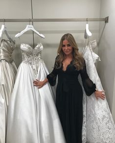 a woman standing in front of some dresses