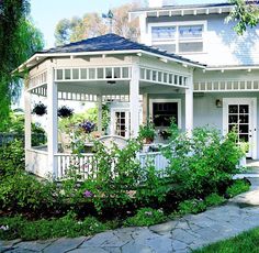 a white house sitting on top of a lush green field