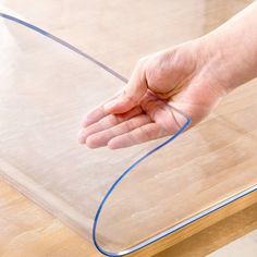 a person is holding their hand out on a piece of clear plastic with blue lines