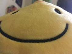 a smiley face stuffed animal sitting on top of a table