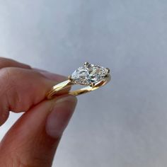 a person holding a diamond ring in their hand