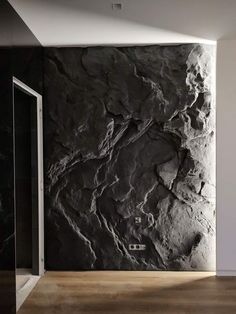 a black and white wall in a room with wood flooring next to a glass door