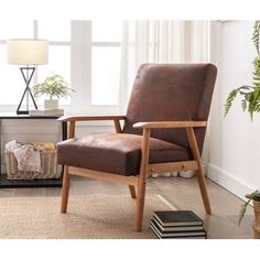 a brown leather chair sitting on top of a wooden floor next to a lamp and window