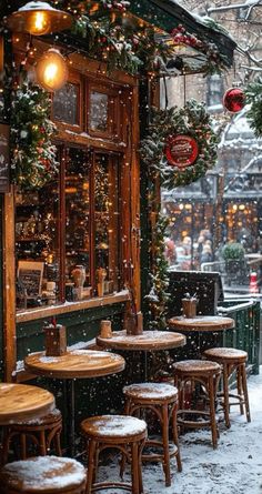 the outside of a restaurant with tables covered in snow and christmas lights hanging from the ceiling