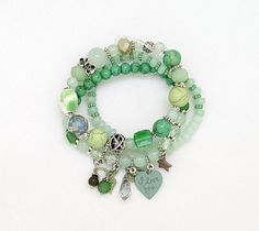 A turq, white, silver multi-strand bracelet or multi-layer bracelet of four separate pieces. This multi-strand wrap bracelet set is put together with tiny gemstones like beads and small assorted pendants (each piece is very similar, but not exact). #tlb #bohogift #bohemianfashion #BohemianBracelet #HippieBracelet Green Multi-strand Hand Wrapped Beaded Bracelets, Green Multi-strand Jewelry With Colorful Beads, Green Adjustable Multi-strand Beaded Bracelets, Green Multi-strand Beaded Bracelets With Faceted Beads, Green Bohemian Multi-strand Beaded Bracelets, Bracelets Green, Hippie Bracelet, Green Gift, Green And Silver