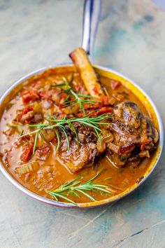 a bowl filled with meat and vegetables on top of a table