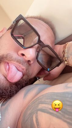 a man sticking his tongue out and wearing glasses with an emoticive expression on his face