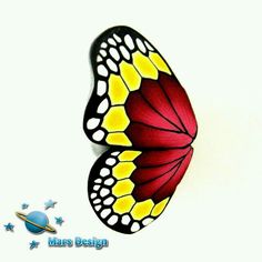 a butterfly with yellow and red wings sitting on top of a white surface next to stars