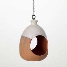 a white and brown bird house hanging from a chain