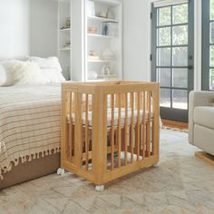 a baby's room with a crib, chair and bed