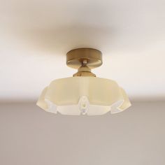 an overhead light fixture in a room with white walls and flooring on the ceiling