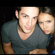 a young man and woman posing for a photo together in front of a cell phone