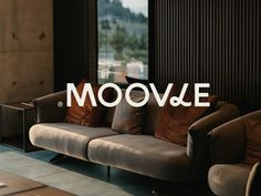 a living room with two couches and a table in front of the window that says mooove