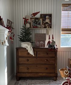 there is a christmas tree on top of the dresser