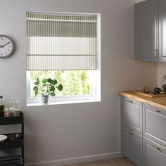 a kitchen with a sink, stove and window in the corner that has blinds on it