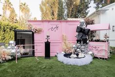 a pink and black party with decorations on the lawn