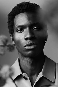 a black and white photo of a young man with short hair wearing a collared shirt