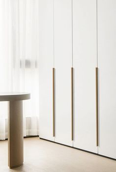 an empty room with white cabinets and a round table in front of the sliding doors