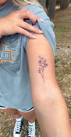 a woman with a flower tattoo on her arm