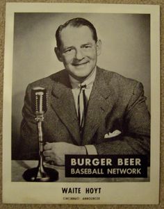 a black and white photo of a man in a suit holding a microphone with the words burger beer baseball network written on it