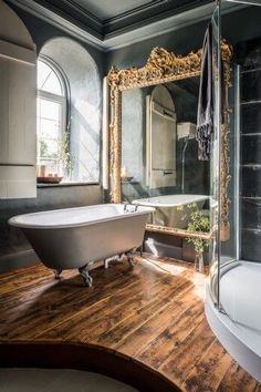 a bathroom with a claw foot tub and wooden floors