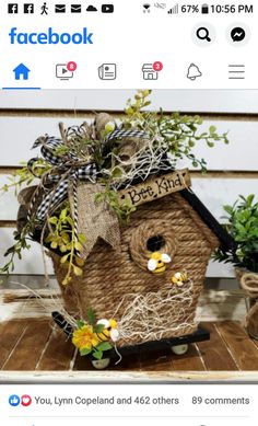 a birdhouse made out of wicker and burlocks with flowers in it