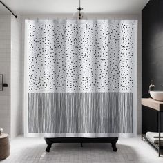 a black and white bathroom with polka dot shower curtain