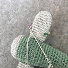 a crocheted stuffed animal holding a knitting needle