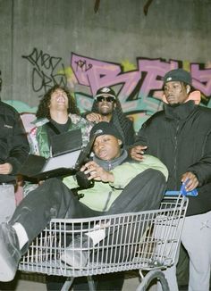 a group of people standing around a shopping cart