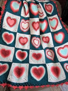 a crocheted blanket with hearts on it