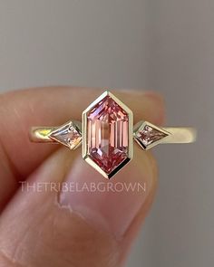 2 Carat Hexagon Cut Pink Moissanite Engagement Ring, 14k Solid Gold Bezel Set Ring ,Side Kite Cut Moissanite Ring, Three Stone Wedding Ring ❖ Ring Details ❖ ➢ Metal Type:- Gold, Rose Gold, White Gold, 925 Sterling Silver (Can Be Customize) ➢ Stone Type:- Lab Diamond/ Moissanite/ Natural Diamond/ Lab Grown Diamond ➢ Band Width:- Approx. 2 MM ➢ Cut:-Hexagon Cut (Can Be Customize As Per Requirement) ➢ Main Stone Size:-9x4.5 MM (Can Be Customize As Per Requirement) ➢ Main Stone Carat Weight:-1.75 Ca Pink Moissanite Engagement Ring, Pink Moissanite Ring, Bezel Set Engagement Ring, Hexagon Diamond, Bezel Set Ring, Pink Sapphire Ring, Engagement Ring Cuts, Moissanite Ring, Pink Stone