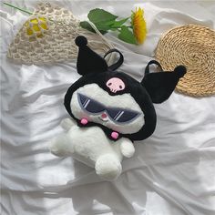 a black and white stuffed animal laying on top of a bed