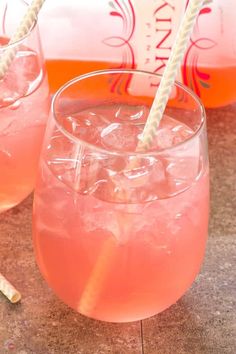 two glasses filled with pink liquid and straws