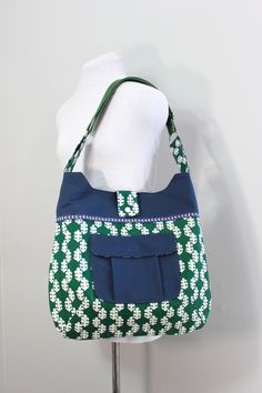 This Chunky Tote (large shoulder bag) is made from a green and white patterned bedsheet and the top of the bag is made from a navy blue bedsheet.  The front of the bag features a pleated pocket with a flap secured with velcro made from the same fabric used for the top of the bag.  Also featured on the bag is blue and white trim on both the front and back of the bag. The lining of this bag is made from a blue and white floral bedsheet, there is a large divided interior pocket to keep things handy Green Rectangular Bag With Side Pockets, Green Cotton Bag With Zipper Pocket, Green Cotton Shoulder Bag With Removable Pouch, Green Reversible Cotton Shoulder Bag, Blue Bedsheet, Blue And White Floral, Large Shoulder Bags, White Trim, White Patterns