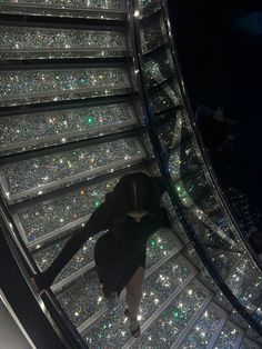 a woman is walking down an escalator with lots of glitters on it