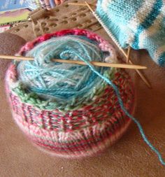 yarn and knitting needles in a basket on the floor