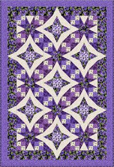 a purple and white quilt with an intricate design on the front, in two different colors