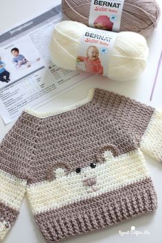 a crocheted monkey sweater next to a ball of yarn