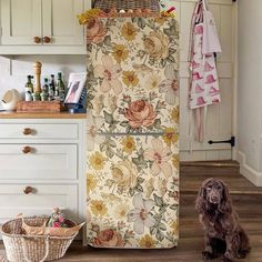 a brown dog sitting in front of a floral print refrigerator freezer next to a wicker basket