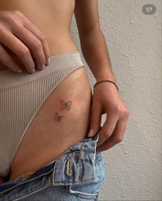 a woman's stomach with a butterfly tattoo on her belly and the bottom part of her pants