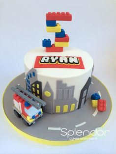 a birthday cake with a fire truck and building blocks on it