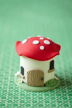 a small toy house with a red roof and white polka dots on it's top