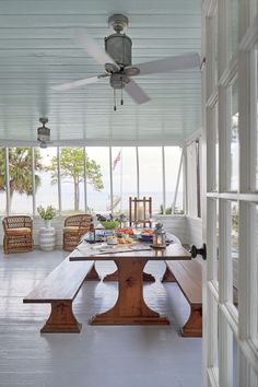 a large wooden table sitting under a ceiling fan