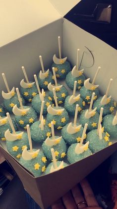 a box filled with blue and yellow cupcakes