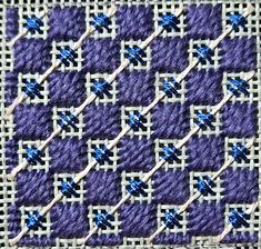 a close up of a purple and white quilt with blue crosses on the center,