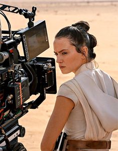 a woman is standing in front of a camera set up for star wars the force awake